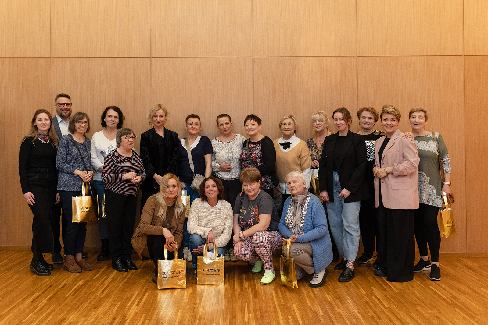 Grupa uczestniczek projektu „Oddech dla Mam” pozuje wspólnie po warsztatach makijażu w Solar Company. Wśród nich przedstawicielki organizatorów i partnerów wydarzenia.